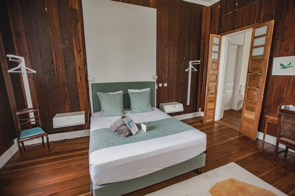 Vue générale de la chambre Chloé, lit queen size et boiseries turquoise