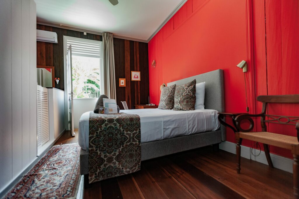 Vue générale de la chambre Marie, lit queen size et mur rouge
