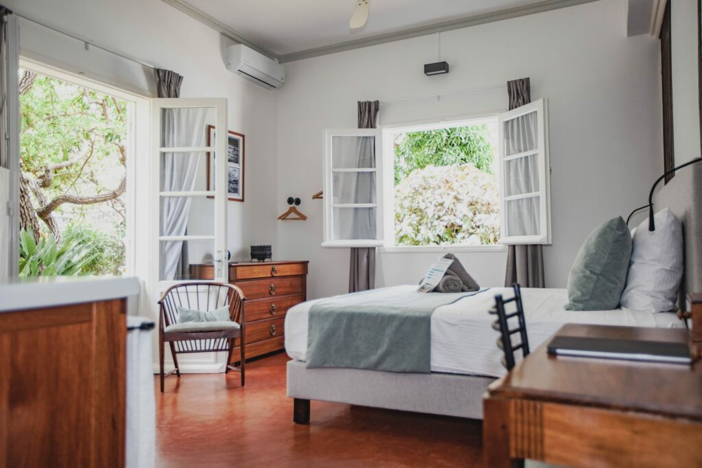 Vue générale de la chambre Muriel, lit king size et fenêtres ouvertes sur le jardin