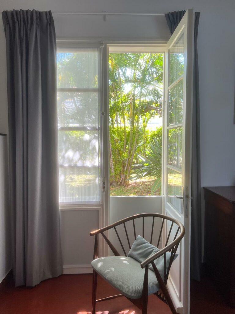 Porte-fenêtre de la chambre Muriel ouverte sur le jardin tropical — Villa Myriam, Saint-Pierre